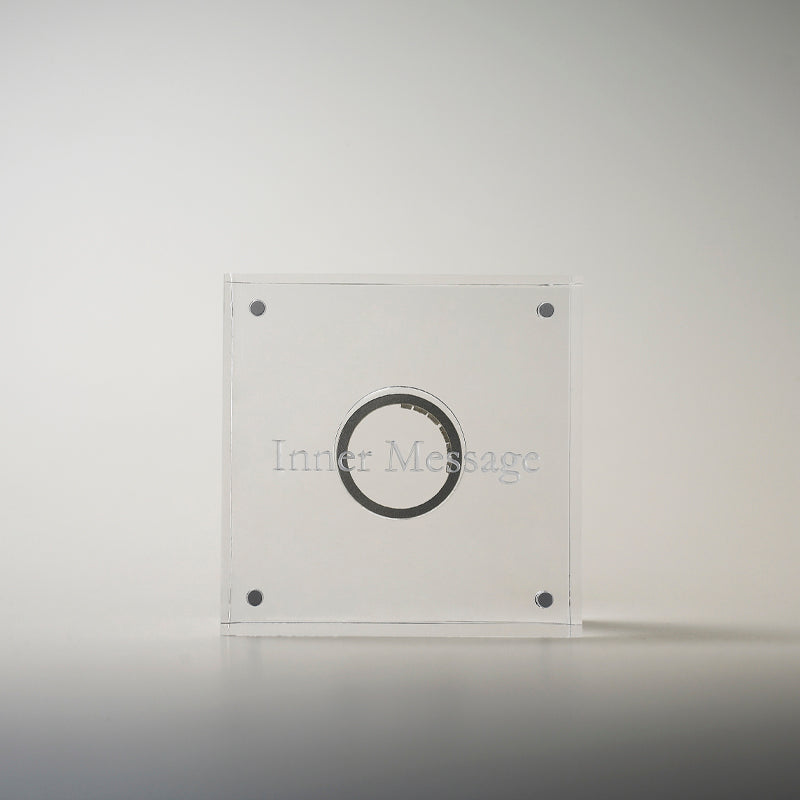 An exquisite acrylic display case designed to enhance the allure of the Inner Message ring, providing a sophisticated and artistic housing for this one-of-a-kind jewelry piece
