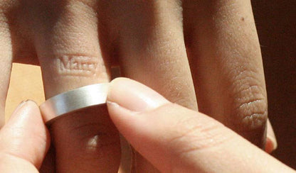 A romantic image showing both the 'Marry me' impression on the finger and the designer-made Inner Message ring with 'Marry me' embossment, creating a unique and sentimental combination